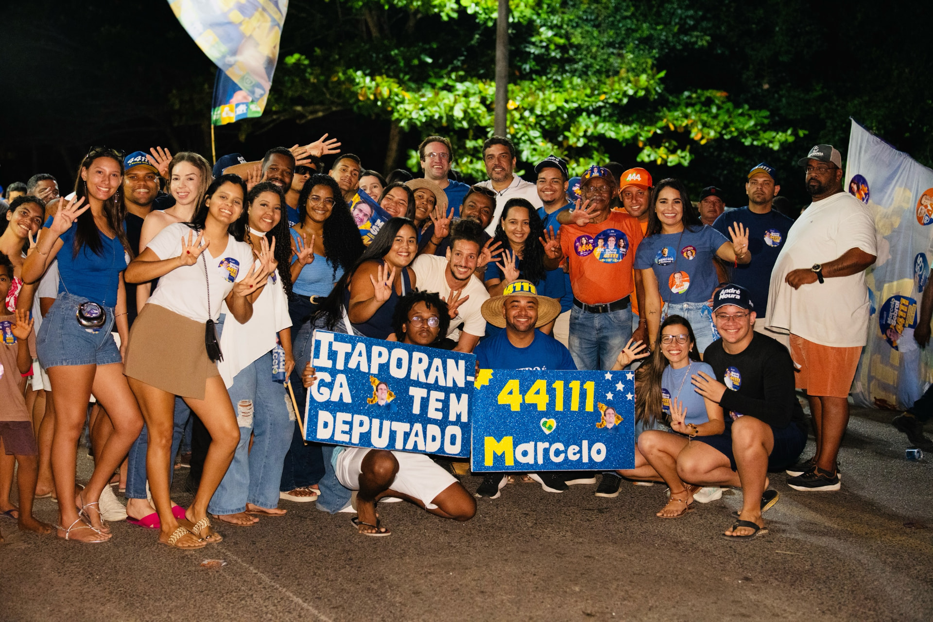 Grupo de moradores e participantes reunido com cartazes durante a programação