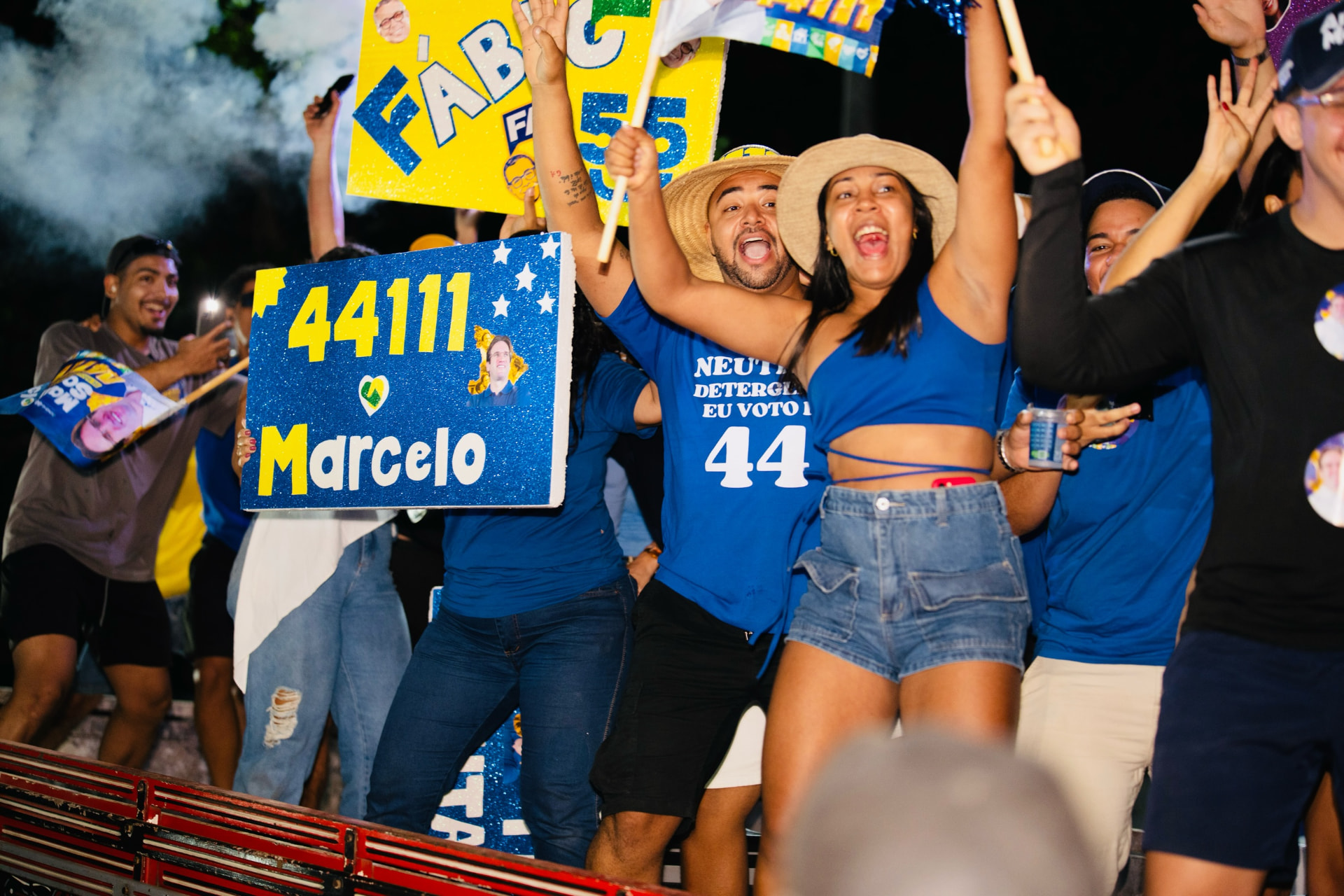 Participantes seguram cartaz com o número 44111 durante a programação noturna